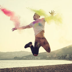 Full length of man jumping against sky