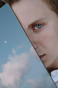 Close-up portrait of teenage girl against sky