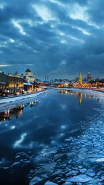 View of illuminated city against cloudy sky
