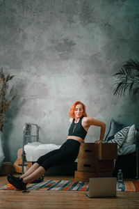 Portrait of young woman sitting on table
