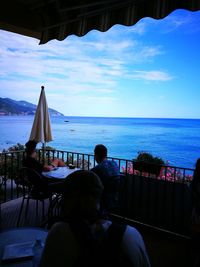 Rear view of man looking at sea against sky