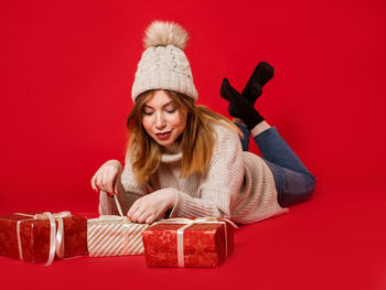 Portrait of a smiling young woman against red background