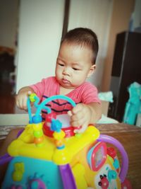 Cute boy playing with toy at home