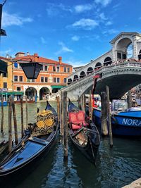 Boats moored in canal against buildings in city