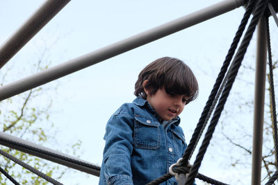 Side view of boy sitting on slide