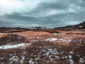 Scenic view of snow covered land against sky