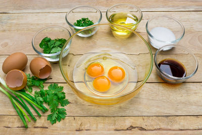 High angle view of egg yolks with various ingredients on table