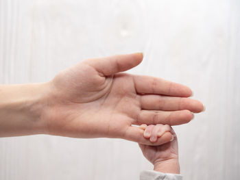 Close-up of baby holding mother hand