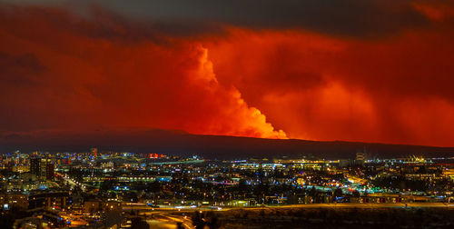 Night view of the volcanic eruption in grindavík  with the town of hafnarfjörður in the foreground.
