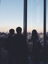 Silhouette of woman against sky at sunset