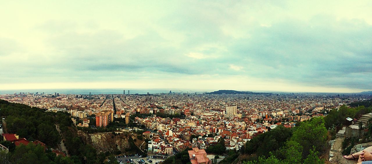 HIGH ANGLE VIEW OF CITYSCAPE AGAINST CLOUDY SKY