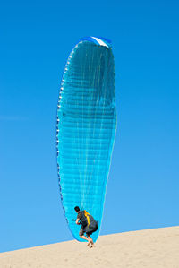 Low angle view of man against blue sky