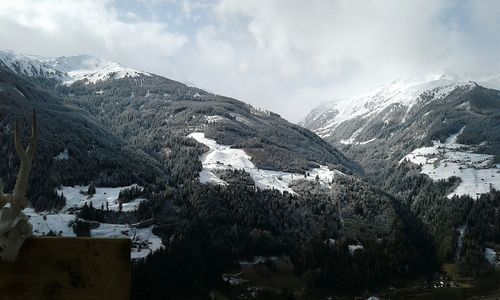 Scenic view of snowcapped mountains against cloudy sky