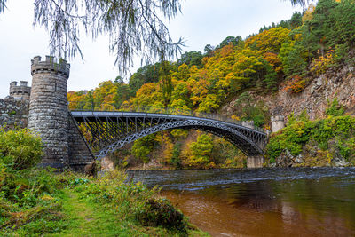 Arch bridge over river against sky