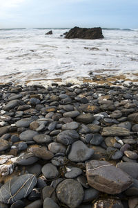 Pebbles on beach against sky