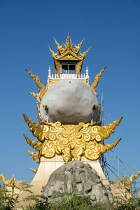 Low angle view of statue against building against clear sky