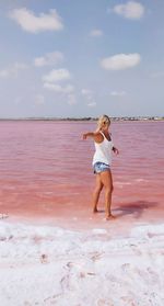 Full length of woman on beach against sky