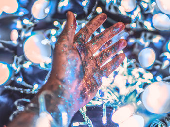 Close-up of hands on illuminated lights