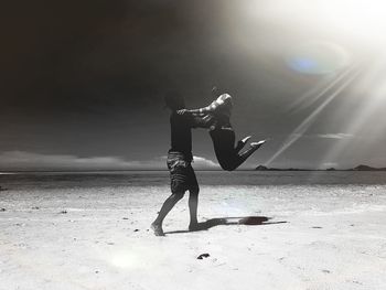 Rear view of woman standing at beach