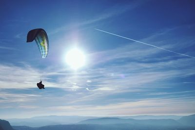 Silhouette of person paragliding against sky