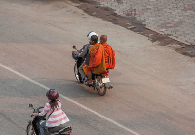 Rear view of man riding bicycle on road