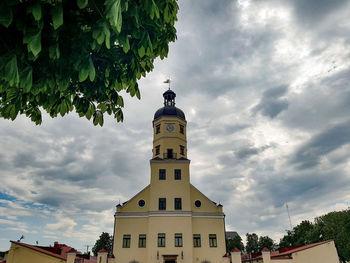 Low angle view of trees and buildings against sky