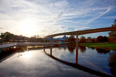 Bridge over river against sky at sunset