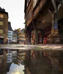 Surface level of puddle on pathway along built structures