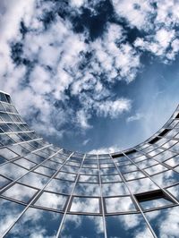 Low angle view of modern building against cloudy sky