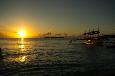 Sailboats in sea against sky during sunset