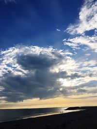 Scenic view of beach against cloudy sky