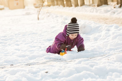 Rear view of child playing in snow