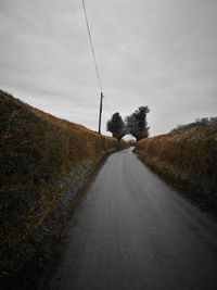 Road amidst trees against sky