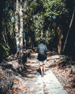 Full length rear view of man walking on footpath