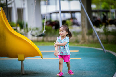 Full length of girl standing by slide