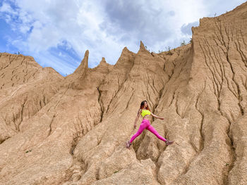 Rear view of woman standing on rock