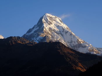 Scenic view of snowcapped mountains against clear blue sky