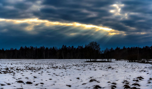 Scenic view of snow covered land against sky during sunset