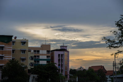 Exterior of buildings in town against sky during sunset