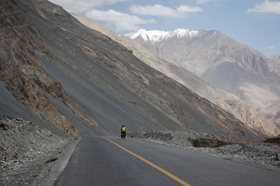 A flat newly built asphalt road leads to the foot of the mountain