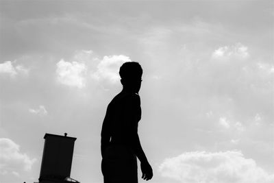 Side view of silhouette young man against sky