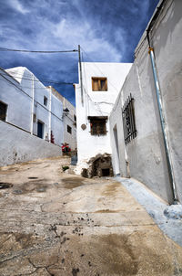 Alley amidst buildings in city against sky