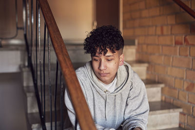 Boy sitting on stairs in residential building