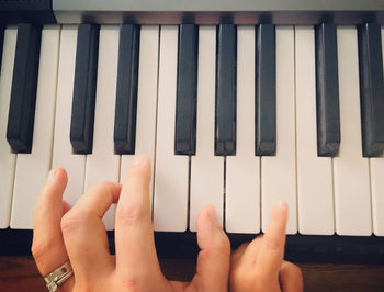 Cropped hands playing piano