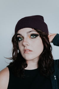 Portrait of young woman against white background