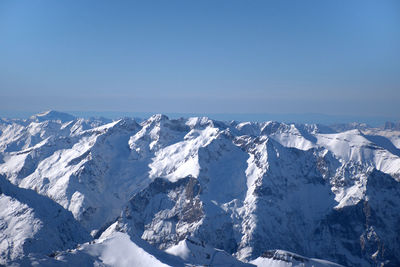 Scenic view of snowcapped mountains against clear blue sky