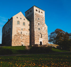Low angle view of old  castle against clear blue sky