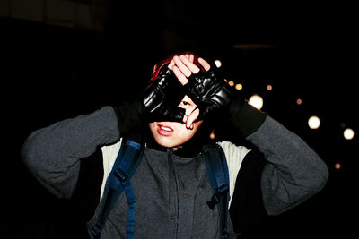 Man looking through hands at night