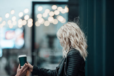 Rear view of woman using mobile phone outdoors