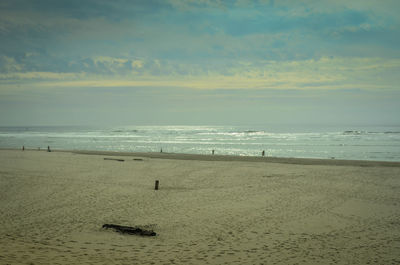 Scenic view of beach against sky at dusk